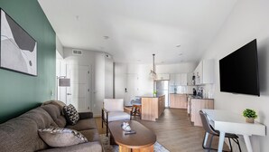 A modern living room with a sofa, coffee table, and dining area. - Landing | Spectacular 2BD, Pool, Yoga Studio (Salt Lake City)