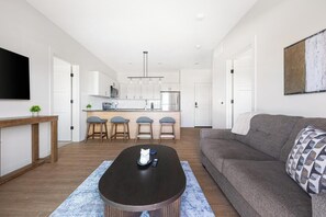 Un salon moderne avec un canapé, une table basse et un téléviseur.