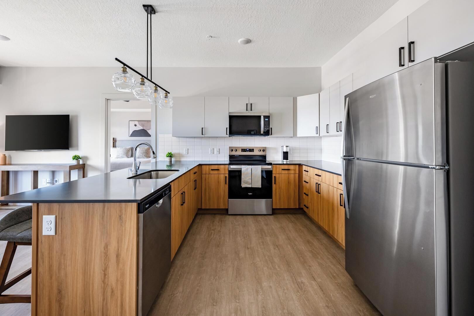 A modern kitchen with stainless steel appliances, wooden cabinets, and a central island.