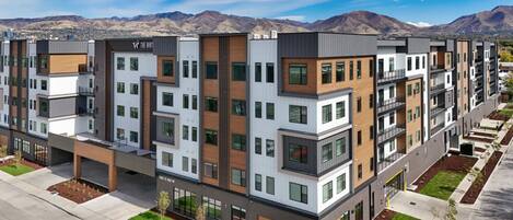 Un edificio residencial de varios pisos con un diseño moderno, que cuenta con balcones, ventanas grandes y un techo plano.