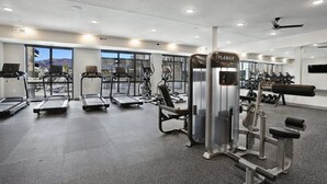 Ein modernes Fitnessstudio mit Laufbändern, Crosstrainern und Gewichten.