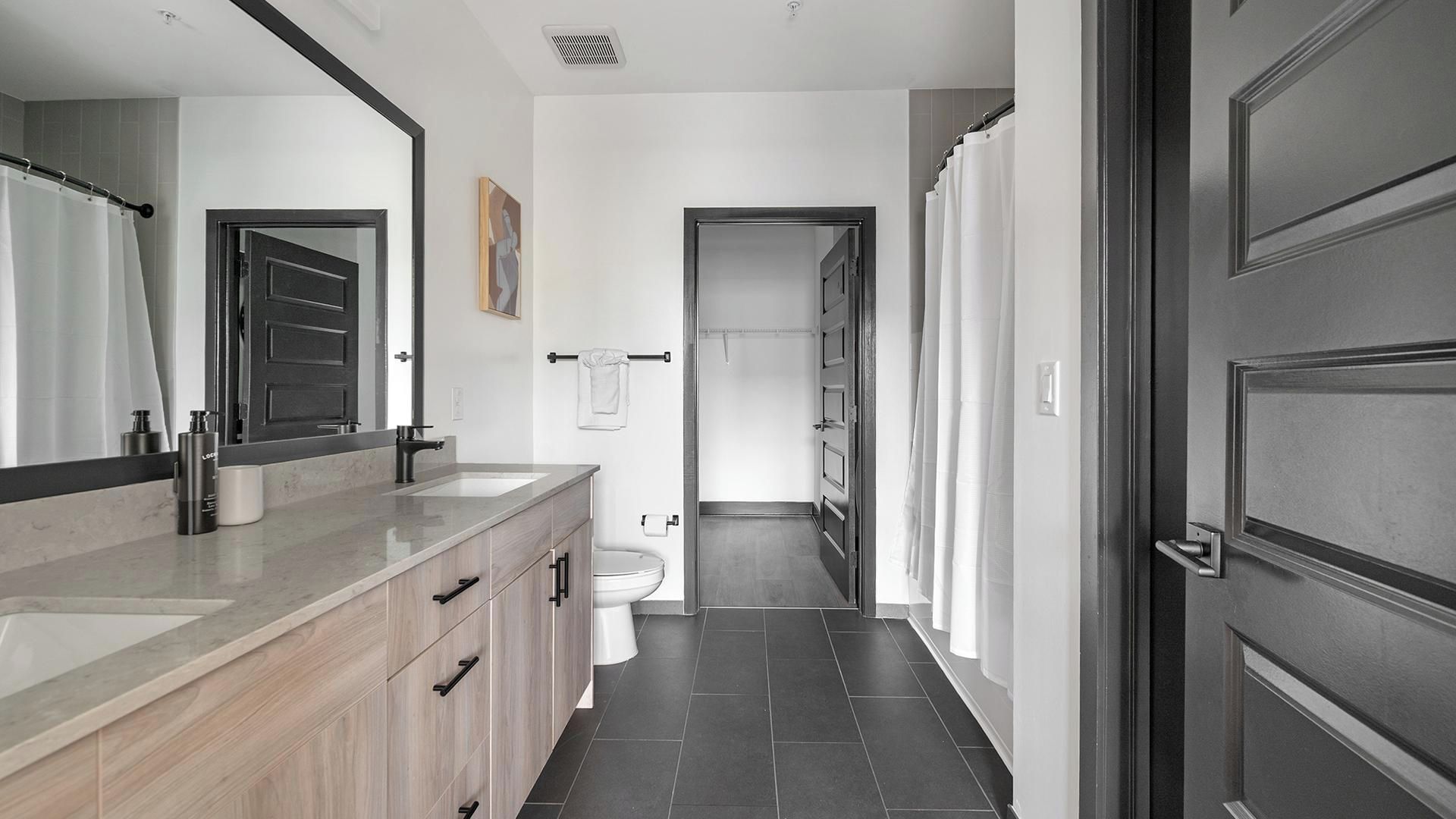 Un baño moderno con tocador, inodoro y zona de ducha.