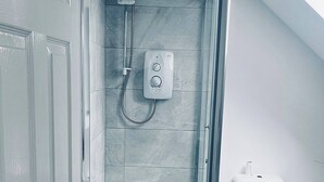 Un baño moderno con ducha, inodoro y lavamanos.