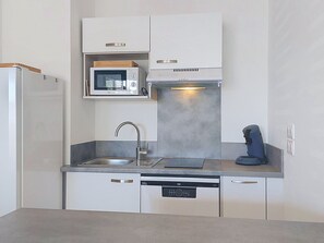 A modern kitchen with a microwave, dishwasher, and coffee machine. - Coeur d'Oléron by Interhome (Ile d'Oléron)