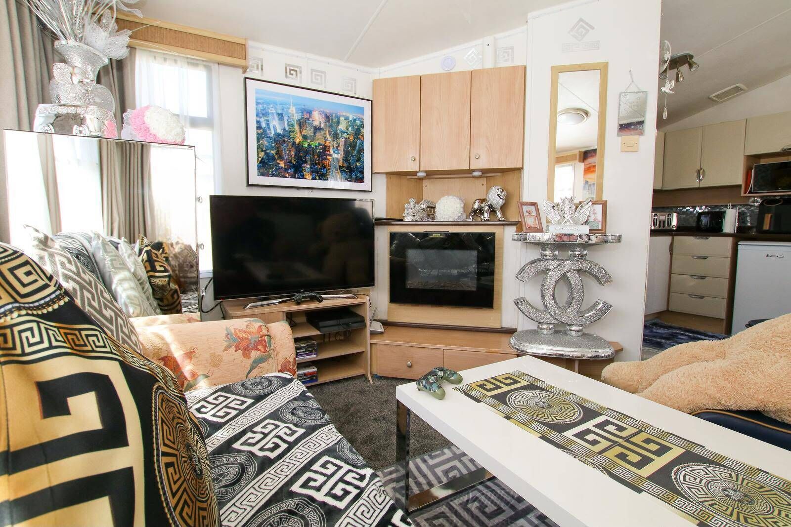 Un salon avec un téléviseur, un canapé et des objets de décoration.