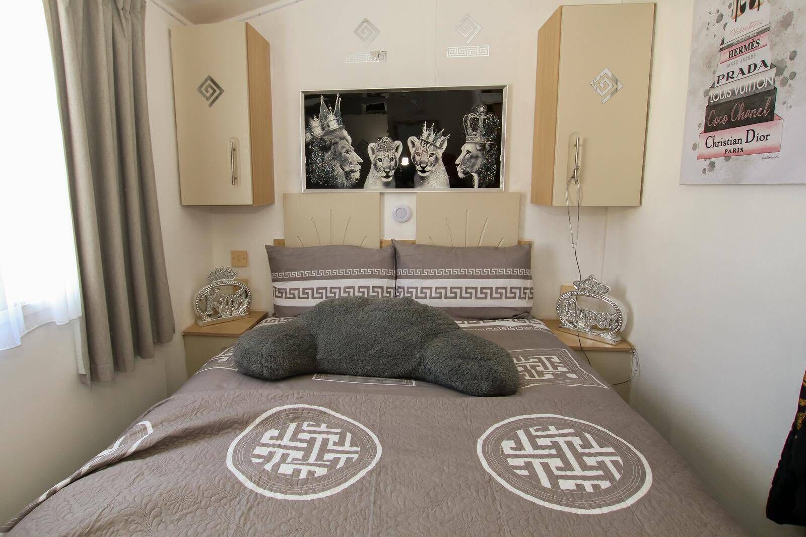 Een slaapkamer met een bed, een spiegel en een poster aan de muur.