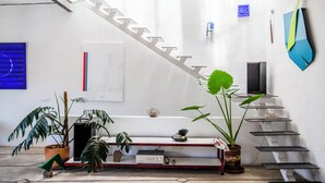 Um interior moderno com escada, plantas em vasos e decoração minimalista.