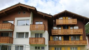 A multi-story building with balconies, a flat roof, and a visible outdoor area. - Weideli Appartement/Fewo 6 Bettwohnung Nr. 21 by Interhome (Saas-Grund)
