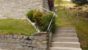 Eine Steinsäule mit einer Holztreppe, die zu einem Gebäude führt.