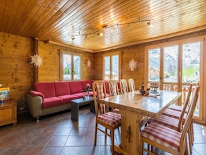 Un intérieur en bois avec un canapé, une table à manger et des chaises.