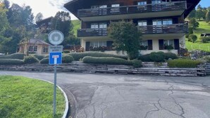 Un immeuble à plusieurs étages doté de balcons, d’une aire de stationnement et d’un panneau indiquant une zone où le stationnement est interdit.