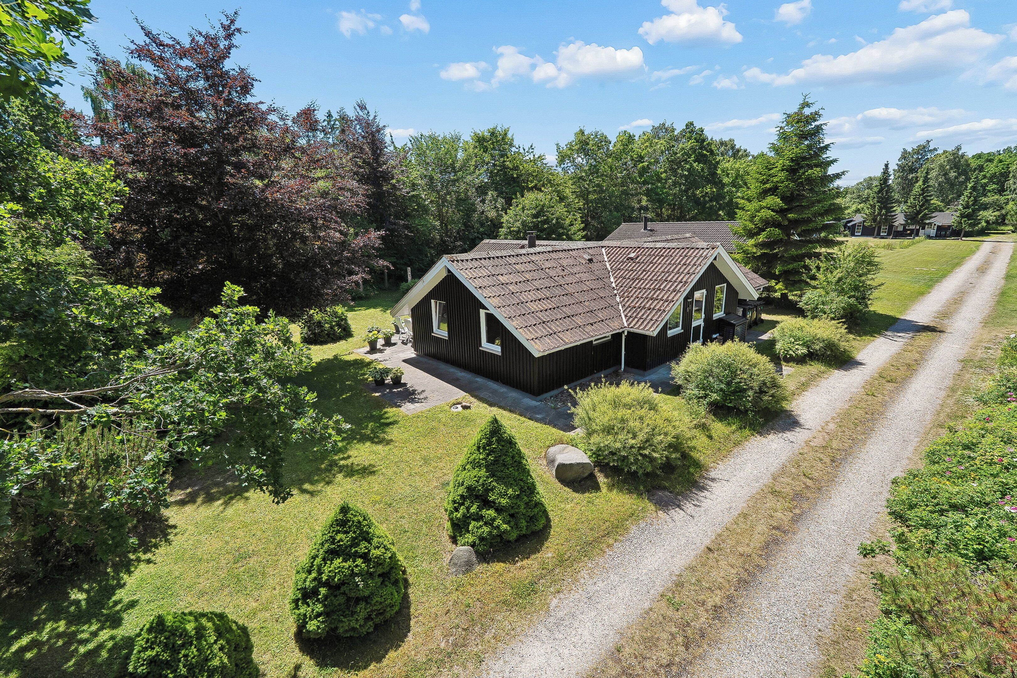 A house with a sloped roof, surrounded by a well-maintained lawn and trees.