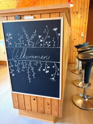 A chalkboard with floral designs and the word 'Welcome' in a hotel setting. - Renovated, 4 rooms, sea view, beach, calm (Nysted)