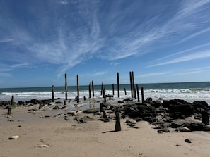 A beach with wooden posts and rocks. - 100m to Aldinga Beach - Stunning new townhouse. (Aldinga Beach)