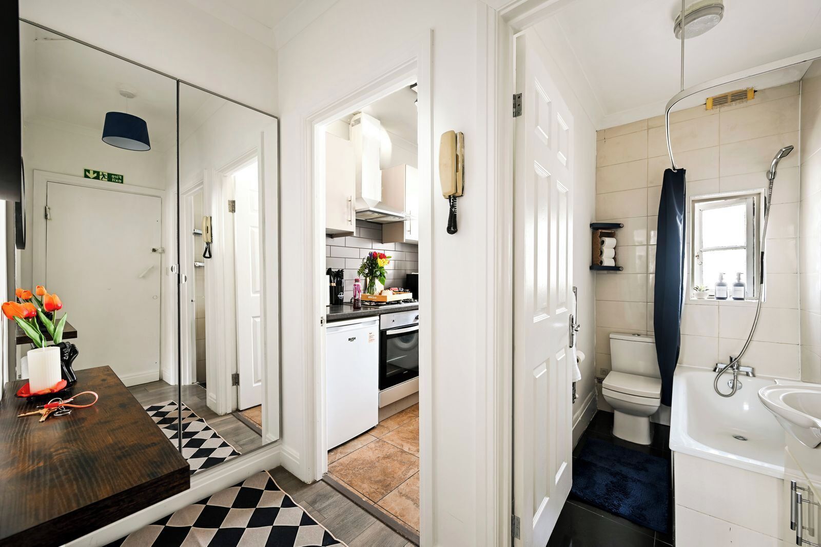 A modern kitchen with a built-in oven and a dining area with a wooden table and chairs.