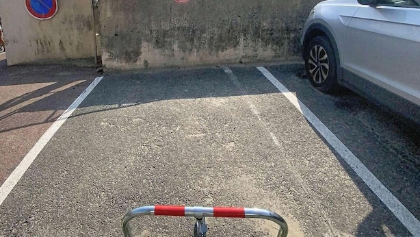A parking area with a gated entrance, a no parking sign, and a car parked inside. - Holiday studio close to the ocean – Ideal for 2 people (LACANAU OCEAN)