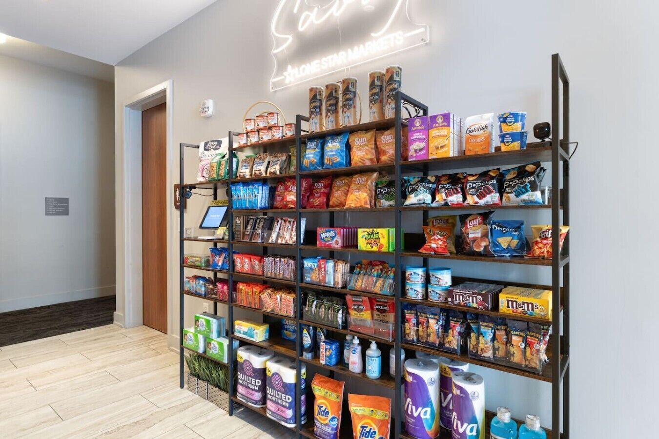 A snack and toiletry aisle in a store with various brands of snacks, chips, and toiletries.