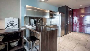 A modern kitchen with stainless steel appliances, a wooden island, and a dark-toned refrigerator. - 50th Floor Luxury Spa Suite at Palms Place (Las Vegas)