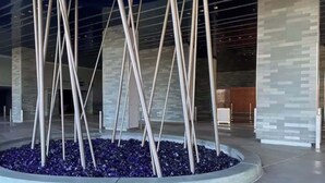 A modern building entrance with a circular seating area and tall, slender columns. - 50th Floor Luxury Spa Suite at Palms Place (Las Vegas)
