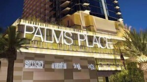 A tall building with the sign 'PALMS PLACE' at the base, featuring a modern architectural design with a prominent vertical element. - 50th Floor Luxury Spa Suite at Palms Place (Las Vegas)