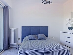 A bedroom with a large bed, a radiator, a desk, and a dresser. - L'Auteuil by Interhome (Cagnes-sur-Mer)