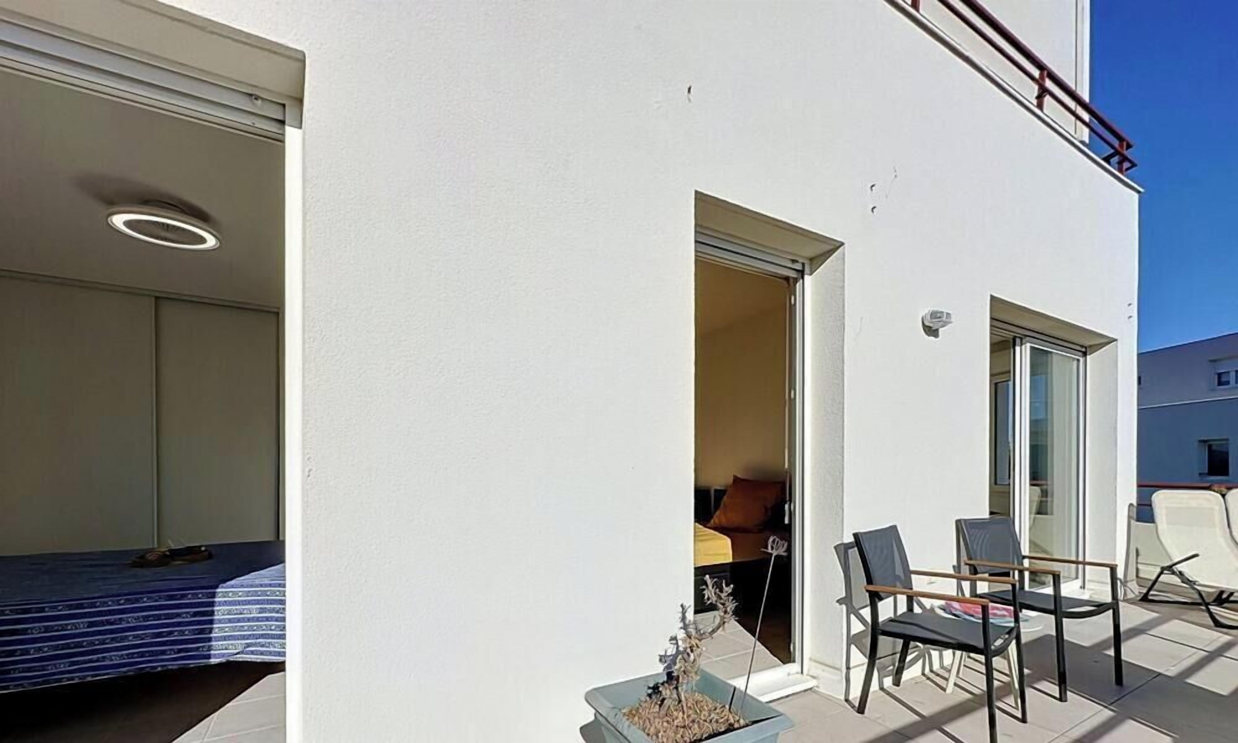 Ein Zimmer mit einem Bett, einem kleinen Tisch und einem Sessel. Ein Fenster bietet Blick ins Freie.