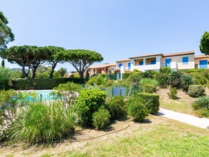Ein Resort mit Schwimmbad, üppiger Vegetation und Gebäuden im mediterranen Stil.