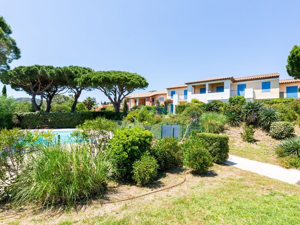 Ein Resort mit Schwimmbad, üppiger Vegetation und Gebäuden im mediterranen Stil.
