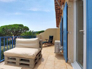 A balcony with a bed, a chair, and a heater. - Les Grenadines by Interhome (Les Issambres)