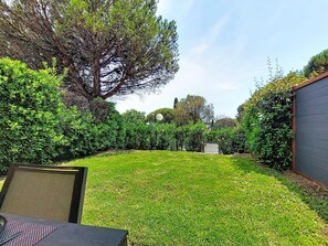 A backyard with a lawn, a chair, and a table. - Les Grenadines by Interhome (Les Issambres)