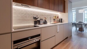 Une cuisine moderne équipée d’un four encastré, d’un évier et d’un grille-pain.