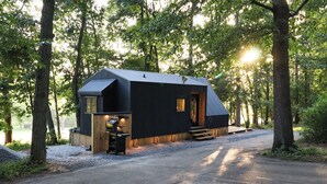 Een chalet met schuin dak, een klein terras en een oprit met grind.