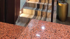 Una escalera con escalones de madera y barandillas metálicas, flanqueada por plantas en macetas.
