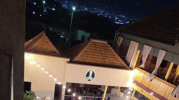 Un hotel con piscina en la azotea, zona de estar al aire libre y letrero de restaurante a la vista.