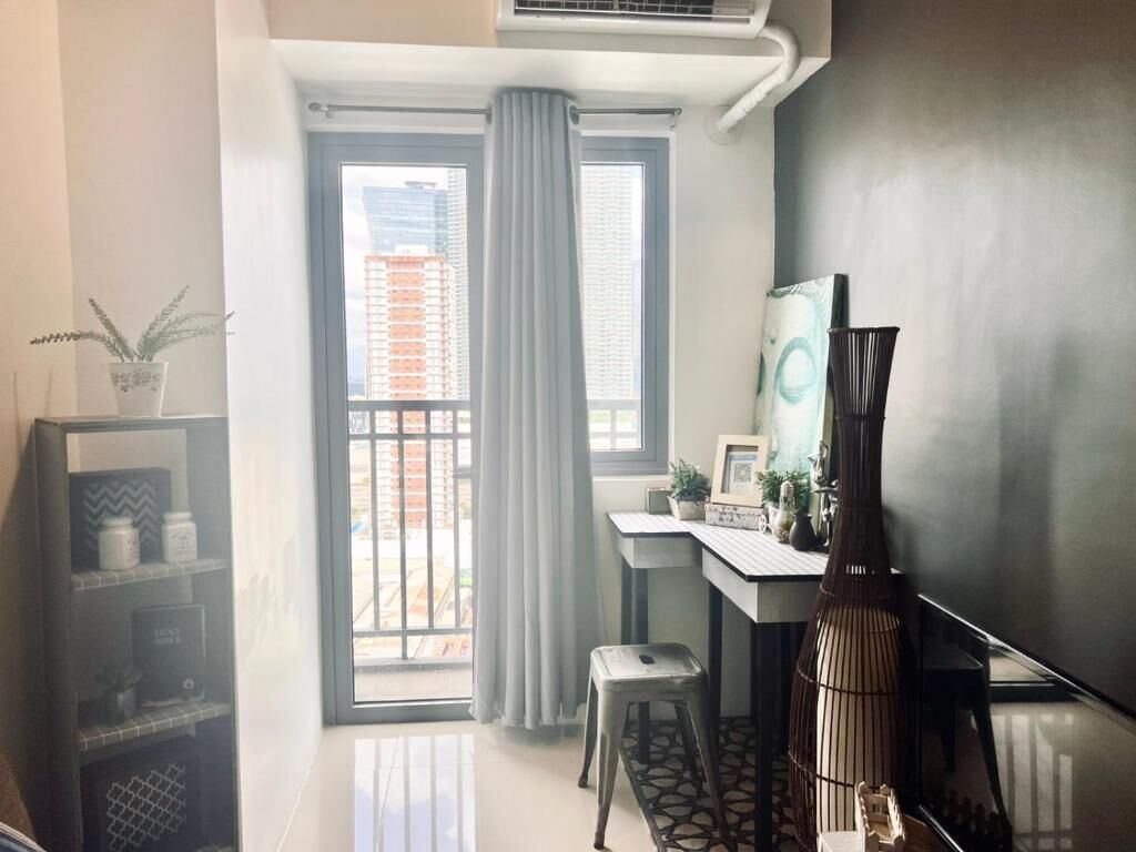 A modern room with a desk, chair, and a large window with curtains.