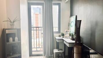 A modern room with a desk, chair, and a large window with curtains.
