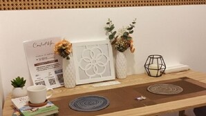 Et træbord med et indrammet billede, en lille potteplante, et lysestage og en dekorativ vase.