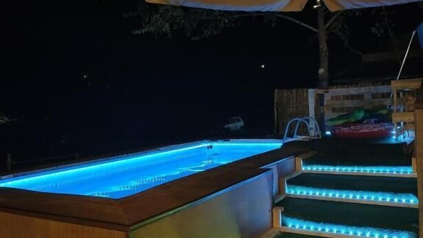 Un área de piscina con escalones y una toldo.
