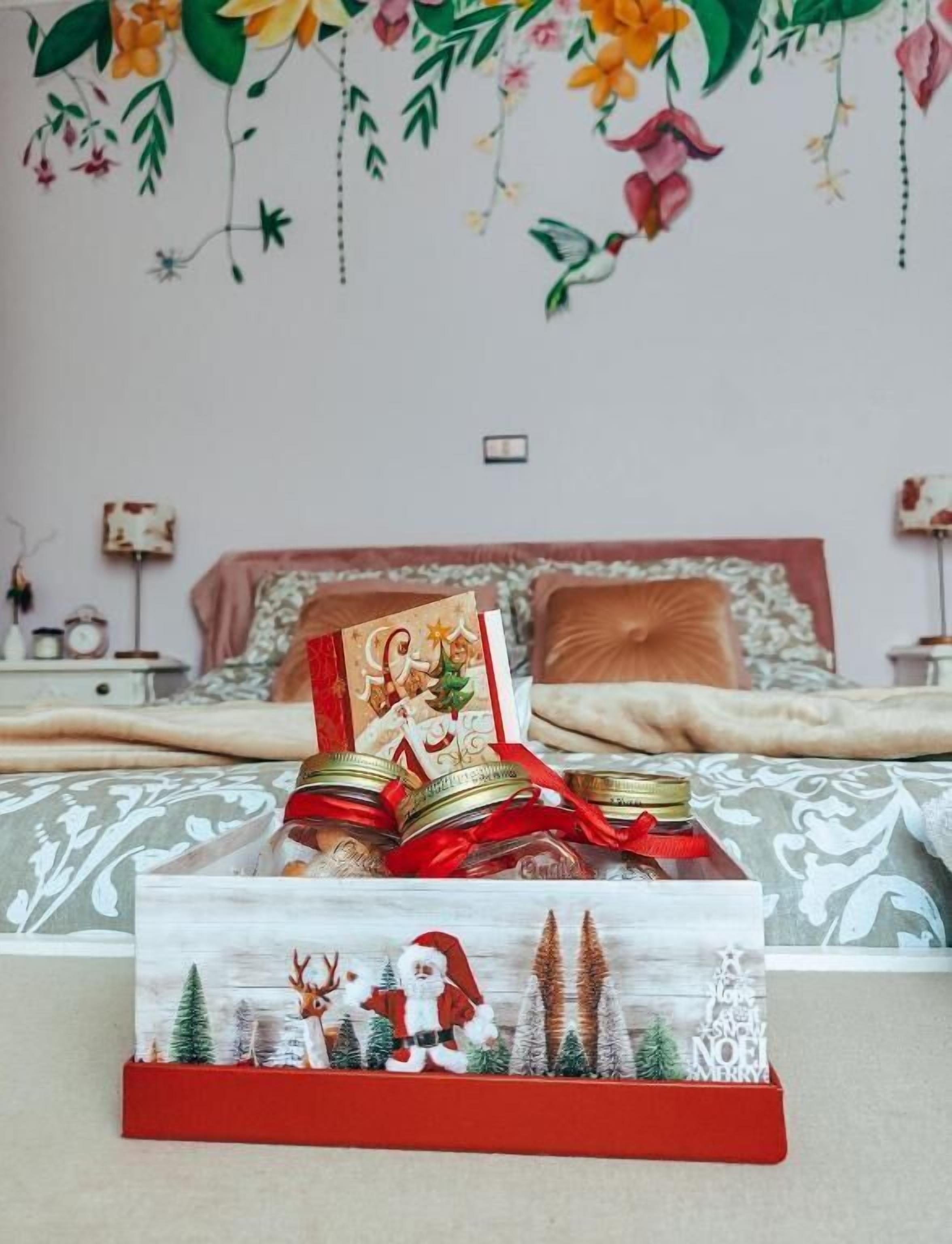 Un dormitorio con cama, almohadas, una mesita de noche y un adorno en la pared.