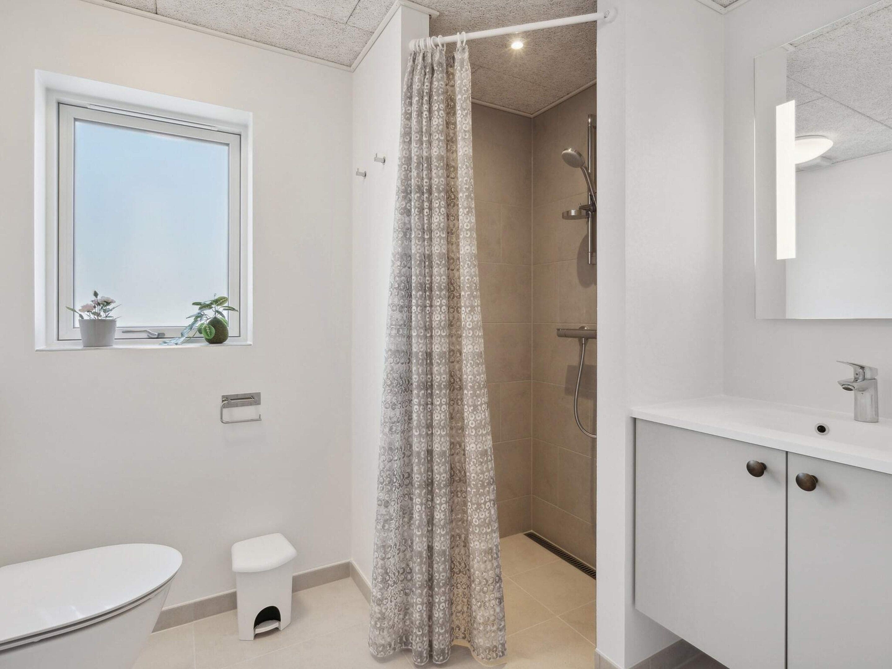Une salle de bain moderne équipée d’une douche, de toilettes et d’un lavabo.