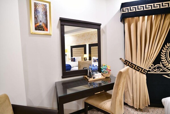 A hotel room with a desk, chair, mirror, and a view of the room's interior. - Royal Regency Hotel (Islamabad)