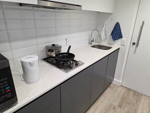 A modern kitchen with a gas stove, a kettle, and a coffee maker. - Fantastic 1-bedroom studio in vibrant Cape Town near top spots (Cape Town)