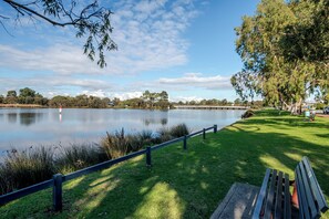 A lakeside park with a bench, a fence, and a bridge in the background. - Riverside 4BR Retreat Shelley|Sleep8|Near Curtin| Min walks to river|CBD|Airport (Shelley)