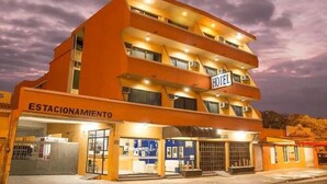 A multi-story hotel with a sign indicating 'HOTEL' and 'ESTACIONAMIENTO' (parking).