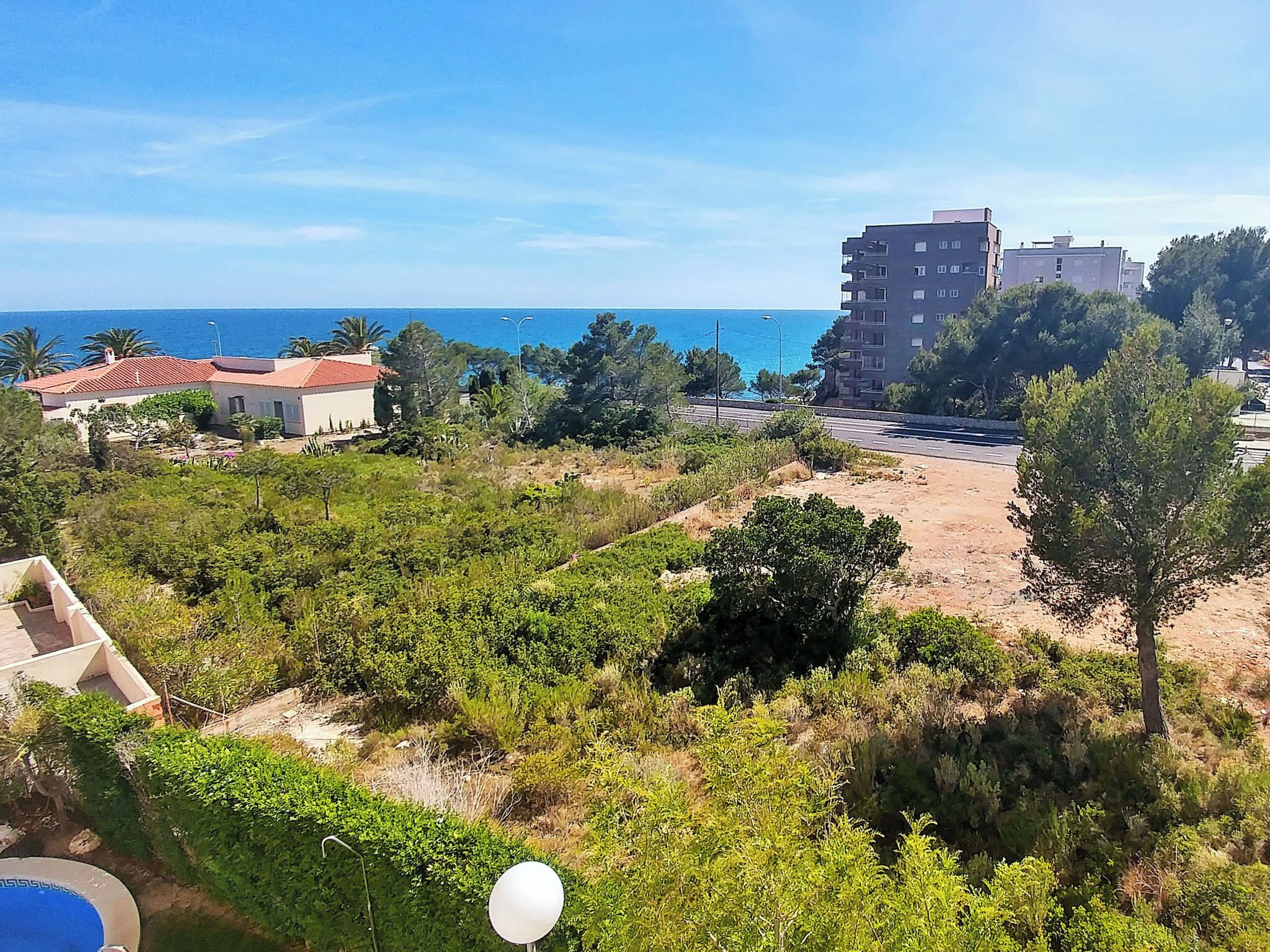 Un quartier résidentiel offrant une vue sur la mer, une route et des bâtiments.