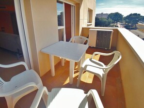 A balcony with a table and chairs, a radiator, and a view of the city. - Coral I by Interhome (Miami Platja)