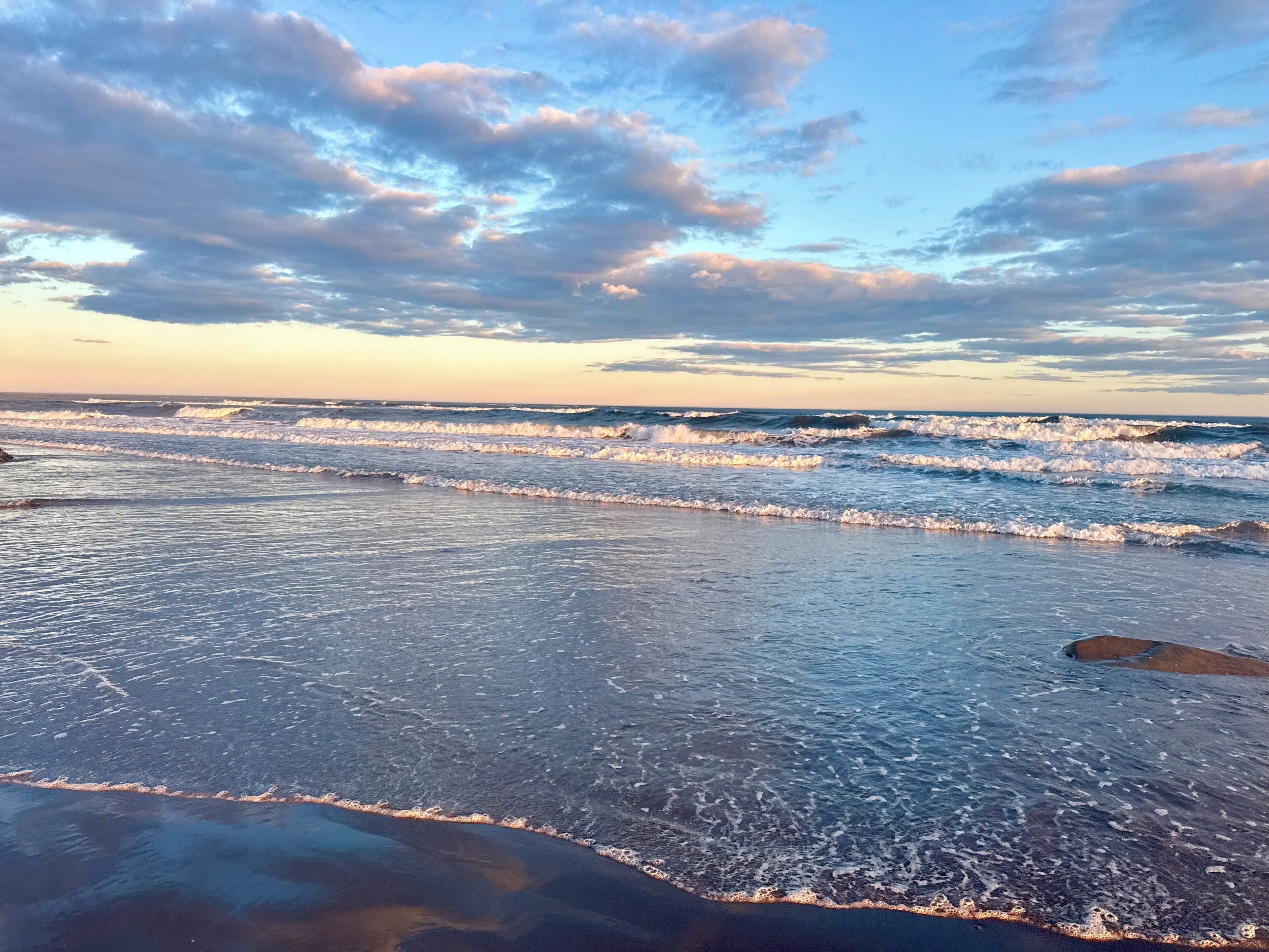 Une plage avec des vagues et un ciel dégagé.