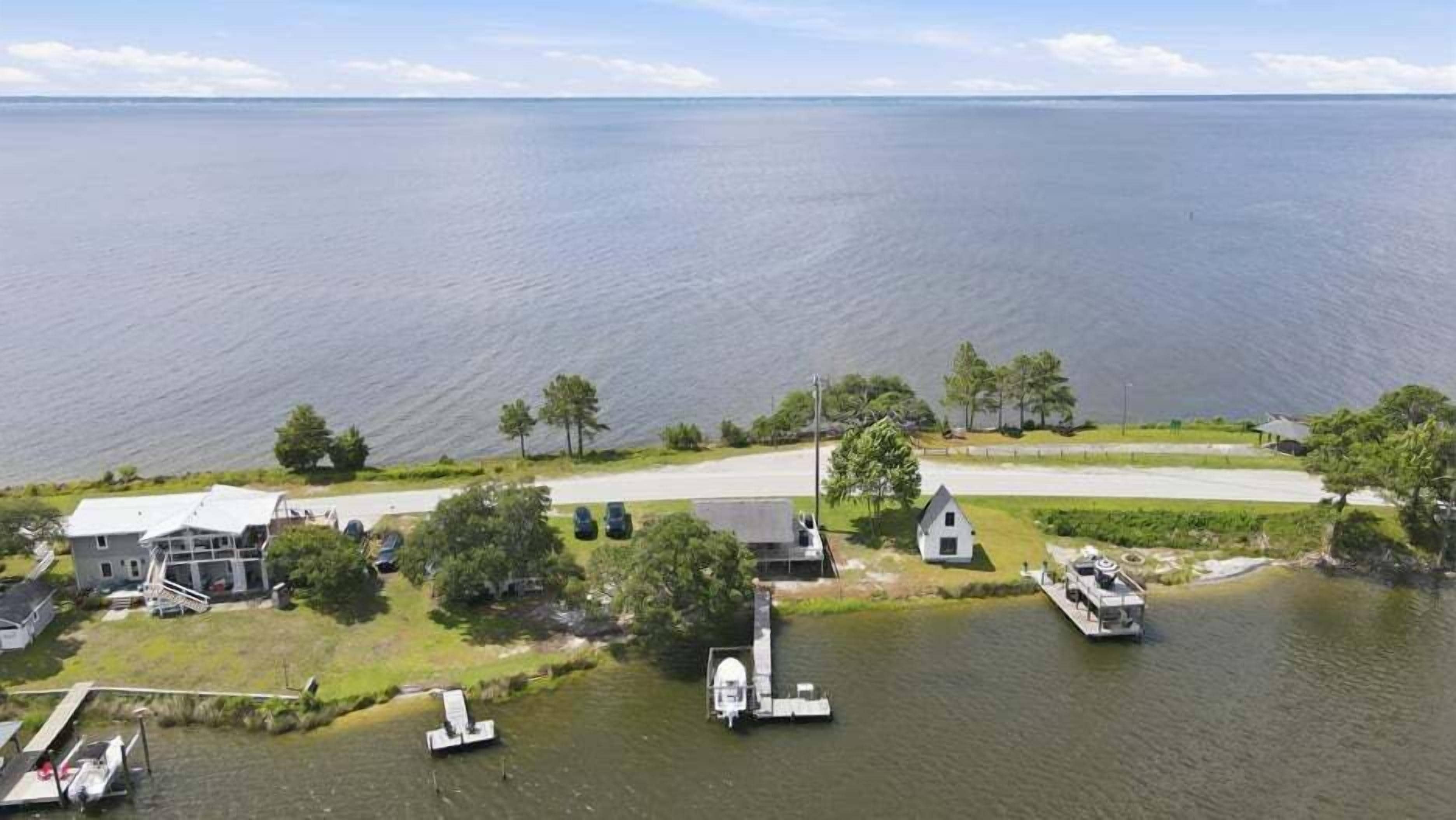 Een vakantiehuis aan het meer, met een aanlegsteiger en boten.