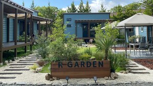 A garden area with a wooden sign labeled 'R GARDEN,' surrounded by a gravel path and various plants. - R GARDEN (Yamanakako)