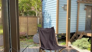 Un área de estar al aire libre techada, con una mesa, sillas y una parrilla.